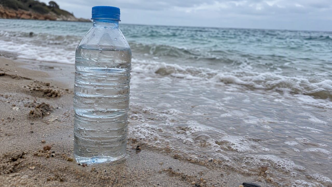Botella de agua de mar en la orilla